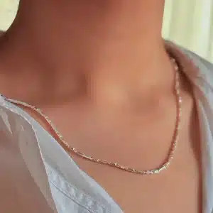 نمای نزدیک از زنجیر نقره ایتالیایی روی گردن با پیراهن سفید پاک کردن